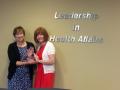 Outgoing NLC Chair Katherine Bullard, left, receives award from new NLC Chair Judith McGurdy, for outstanding service to the organization.